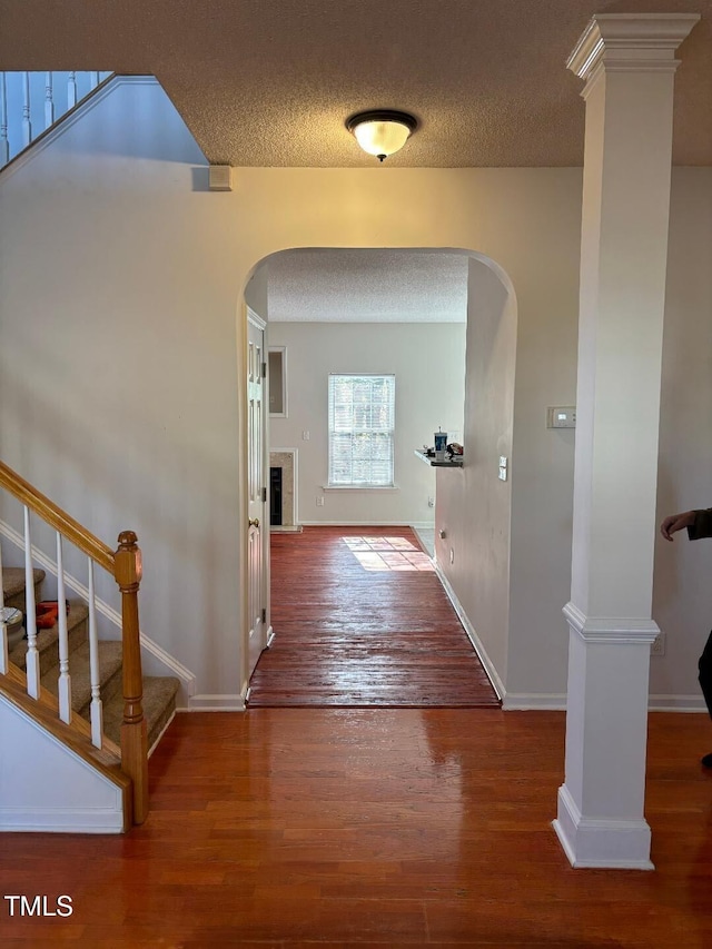 corridor featuring wood-type flooring and a textured ceiling