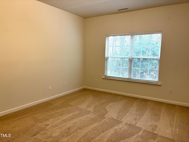 carpeted spare room featuring a textured ceiling