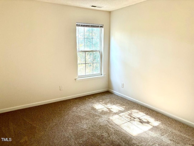 carpeted empty room with a textured ceiling