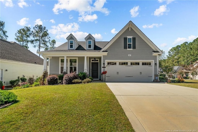 view of front of home featuring covered porch, a front yard, and a garage