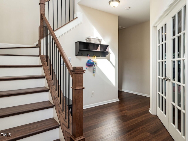 stairway with french doors and wood-type flooring