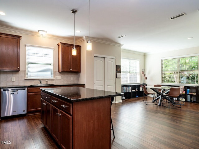 kitchen featuring pendant lighting, dark hardwood / wood-style flooring, stainless steel dishwasher, backsplash, and a center island