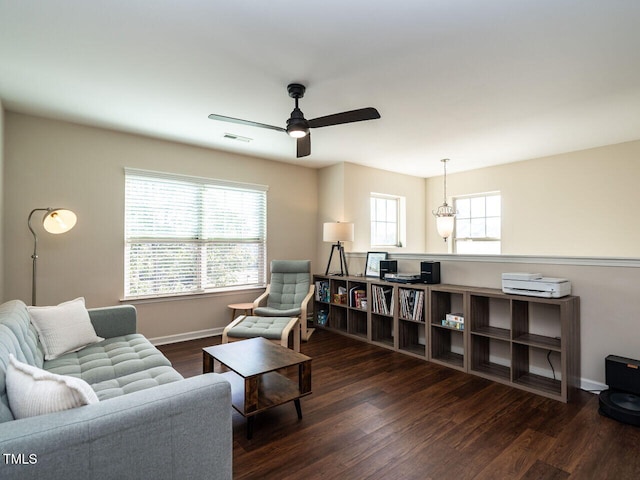 living room with ceiling fan with notable chandelier and dark hardwood / wood-style floors