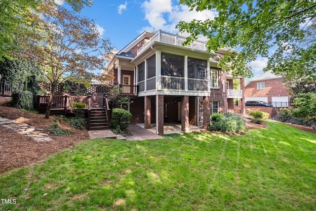 back of house with a patio, a sunroom, a deck, and a lawn