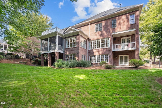 rear view of property with a balcony and a lawn