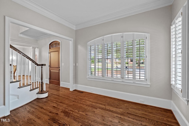 foyer entrance featuring dark wood-type flooring, crown molding, and decorative columns