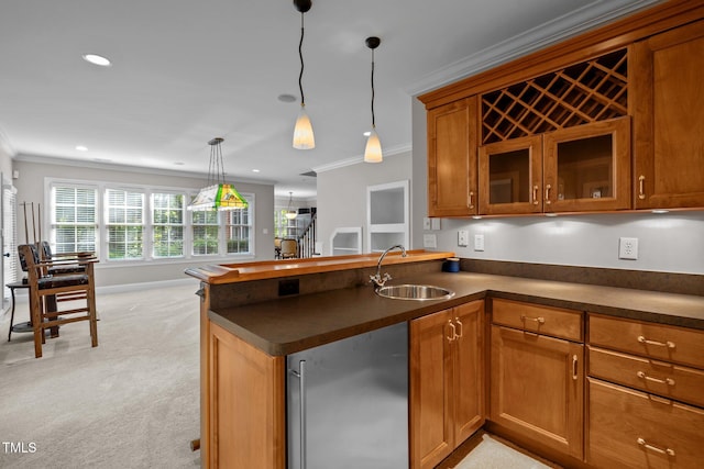 kitchen featuring light colored carpet, kitchen peninsula, ornamental molding, and decorative light fixtures