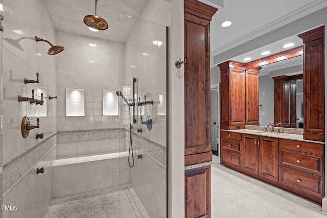 bathroom featuring vanity, a tile shower, ornamental molding, and tile patterned flooring