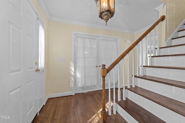 entrance foyer with an inviting chandelier, crown molding, and dark wood-type flooring