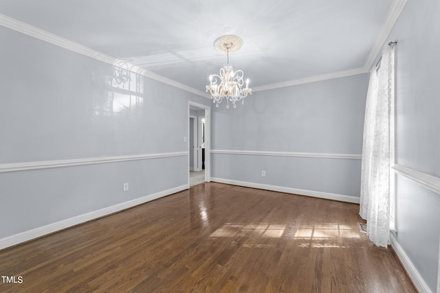 spare room featuring an inviting chandelier, crown molding, and dark wood-type flooring