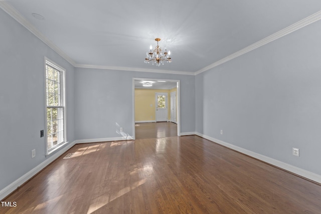 unfurnished room featuring ornamental molding, an inviting chandelier, and dark hardwood / wood-style flooring