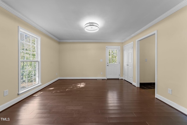 empty room with plenty of natural light, dark hardwood / wood-style floors, and ornamental molding