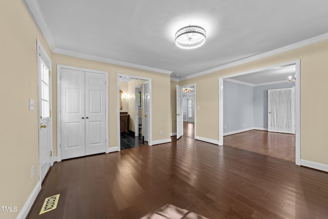 empty room with crown molding and dark wood-type flooring