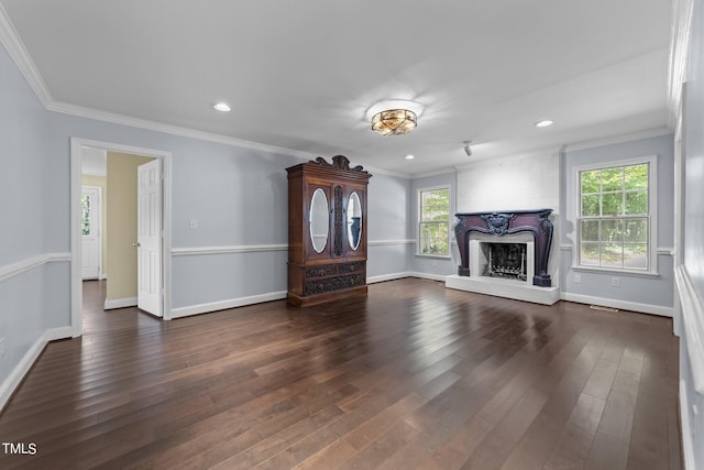 unfurnished living room featuring dark hardwood / wood-style floors, ornamental molding, and a large fireplace