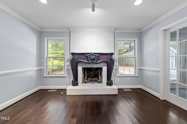 unfurnished living room featuring a healthy amount of sunlight, crown molding, and dark hardwood / wood-style flooring