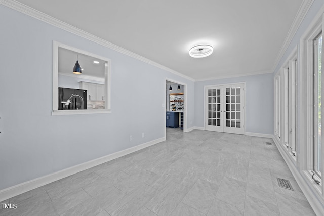 unfurnished room featuring crown molding and french doors