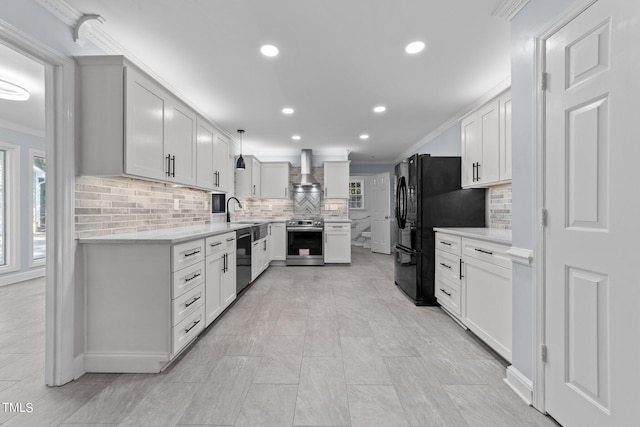 kitchen with wall chimney range hood, crown molding, decorative light fixtures, stainless steel appliances, and white cabinets