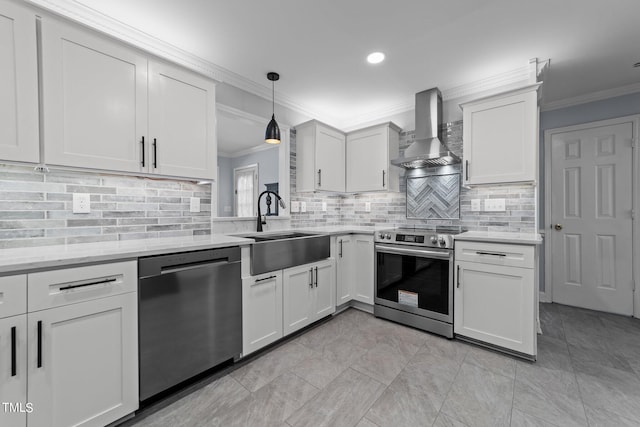 kitchen featuring wall chimney exhaust hood, pendant lighting, sink, stainless steel appliances, and white cabinets