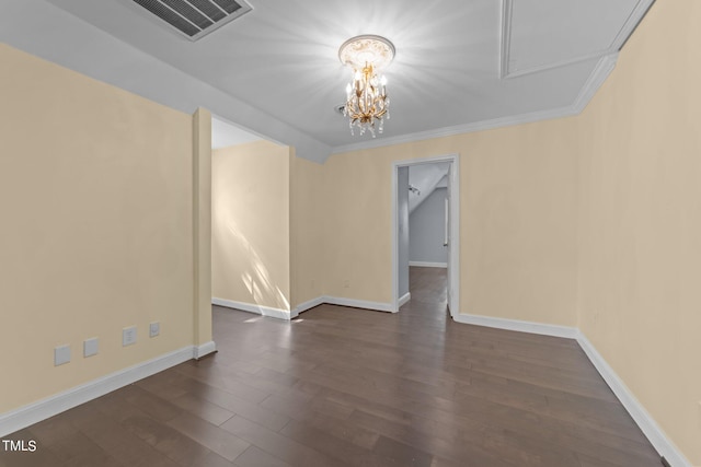 empty room featuring a notable chandelier, crown molding, and dark hardwood / wood-style flooring