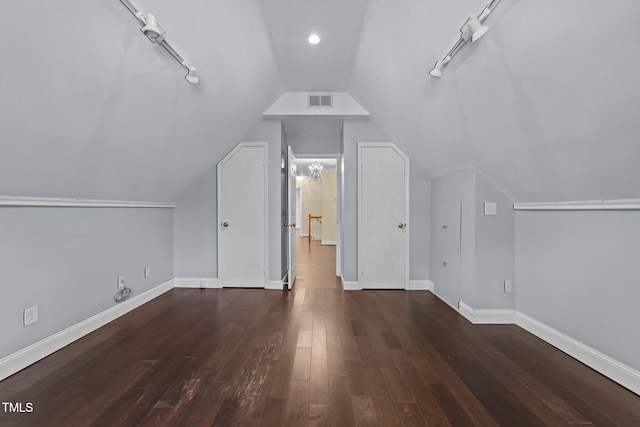 additional living space featuring vaulted ceiling and dark hardwood / wood-style flooring