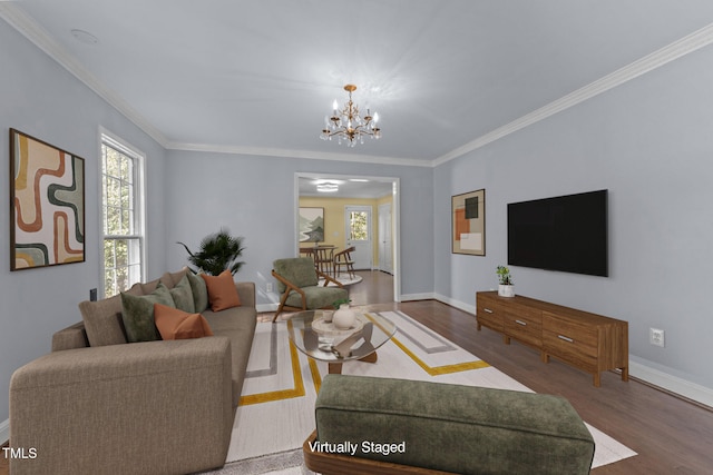 living room featuring wood-type flooring, ornamental molding, and a chandelier