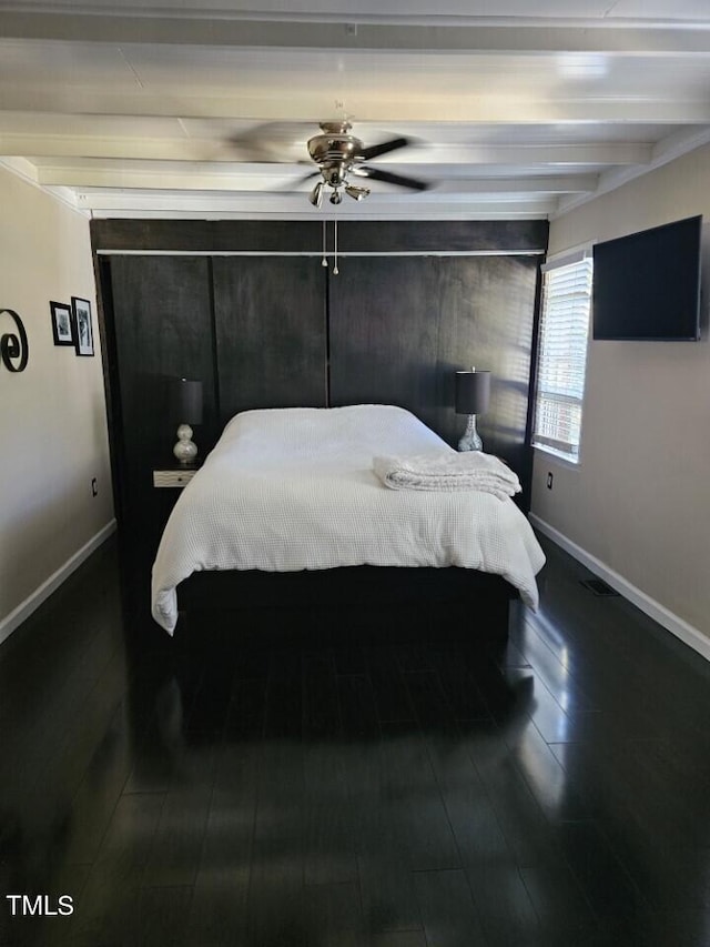 bedroom featuring crown molding, beam ceiling, dark wood-type flooring, and ceiling fan