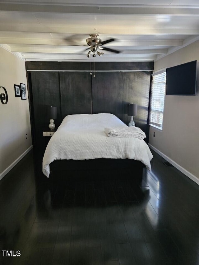 bedroom with a ceiling fan, baseboards, dark wood-style floors, and beam ceiling