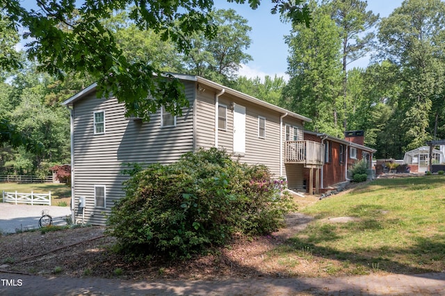 view of property exterior with fence and a yard