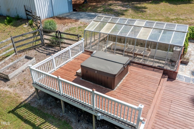 wooden deck with a covered hot tub, an outdoor structure, and a greenhouse