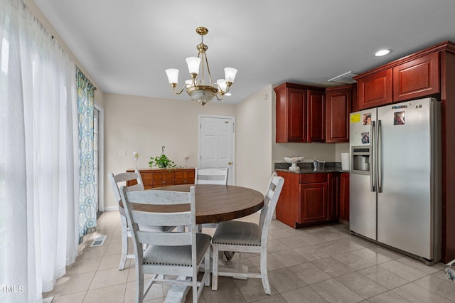 tiled dining space featuring an inviting chandelier