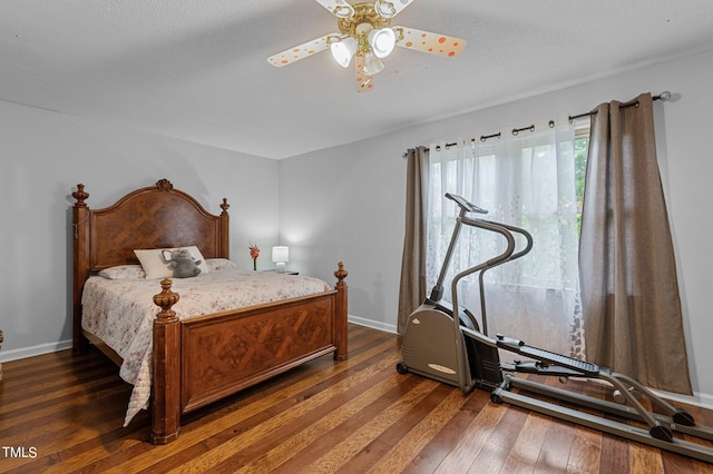 bedroom with ceiling fan, dark hardwood / wood-style floors, and a textured ceiling