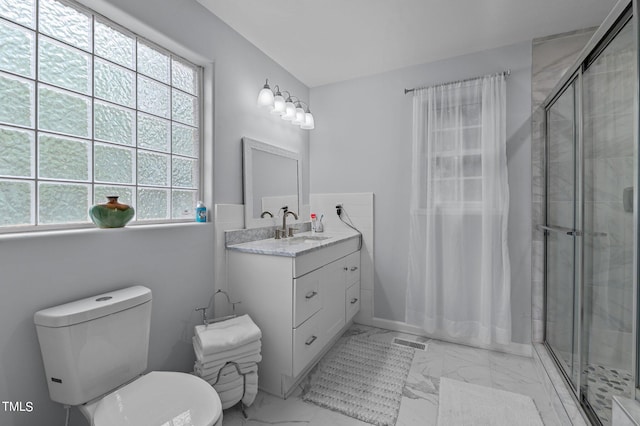 bathroom with vanity, toilet, and a shower with door