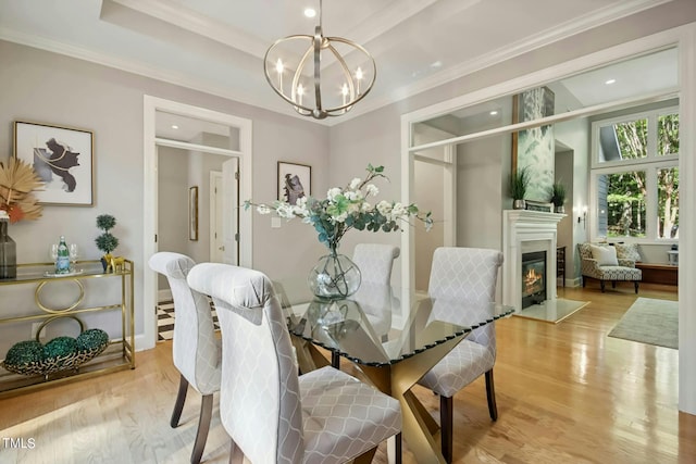 dining room with crown molding, a chandelier, and light wood-type flooring