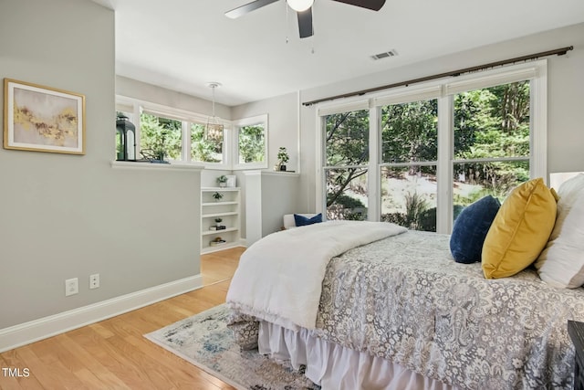 bedroom featuring wood finished floors, visible vents, baseboards, and ceiling fan