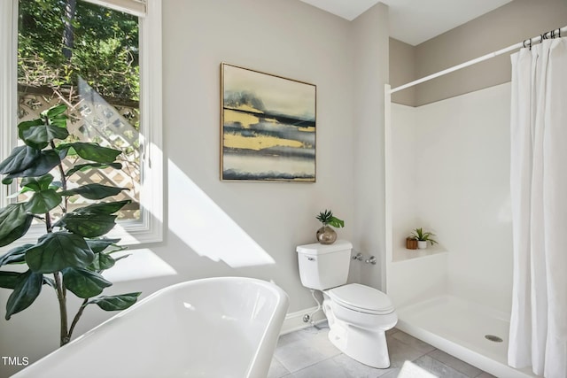 full bathroom featuring tile patterned floors, toilet, baseboards, a freestanding tub, and a shower stall