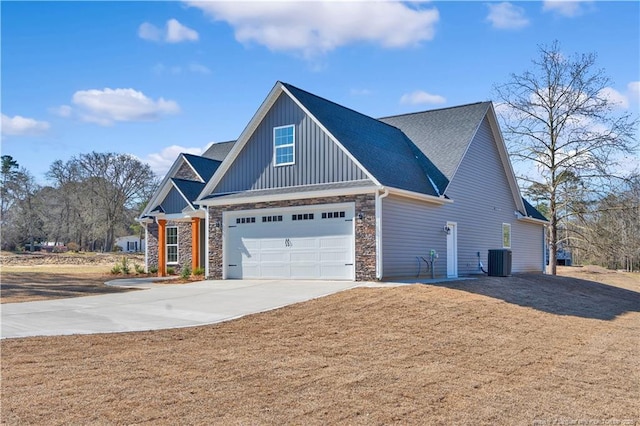 view of front facade featuring cooling unit, stone siding, driveway, a front lawn, and board and batten siding