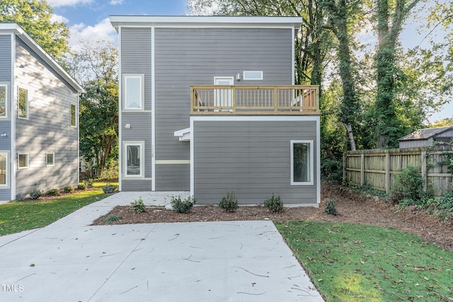 back of property with fence, a patio area, and a balcony