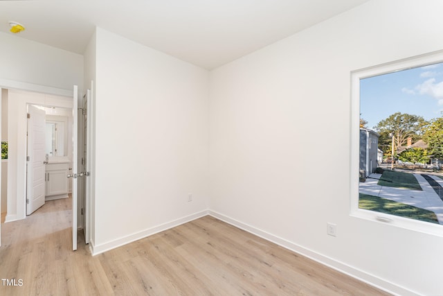 empty room featuring light wood-type flooring and baseboards
