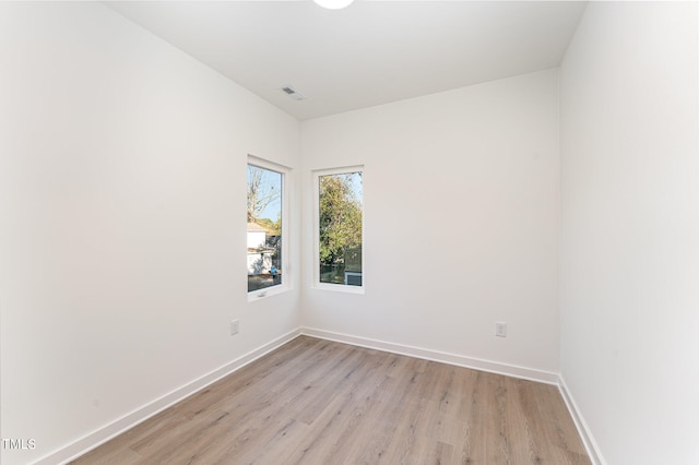 empty room with baseboards, visible vents, and light wood-style floors