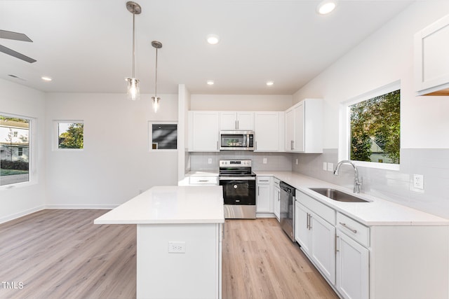 kitchen featuring backsplash, a wealth of natural light, appliances with stainless steel finishes, and a sink