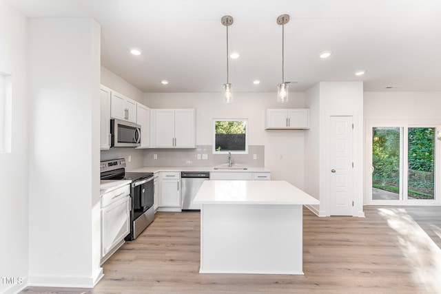 kitchen featuring a kitchen island, a wealth of natural light, stainless steel appliances, and a sink