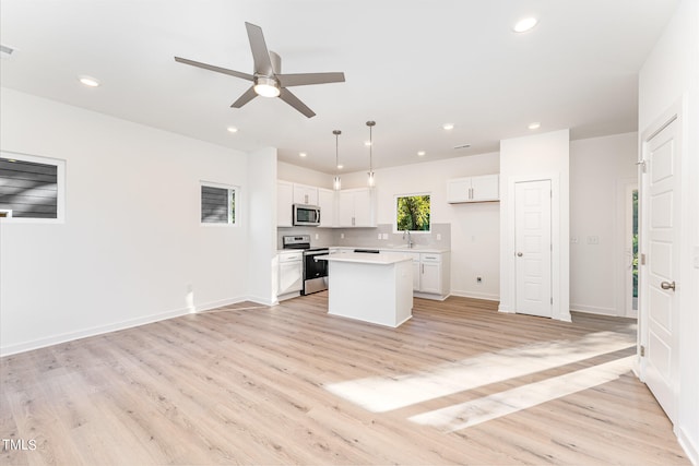 kitchen with white cabinets, stainless steel appliances, light wood-style floors, and ceiling fan