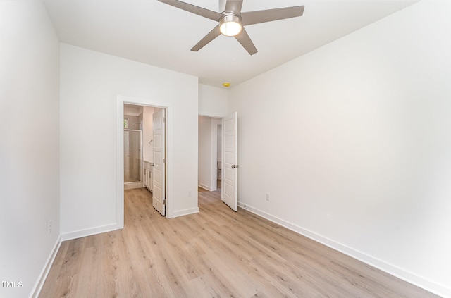 unfurnished bedroom featuring light wood-style flooring, baseboards, ensuite bathroom, and a ceiling fan