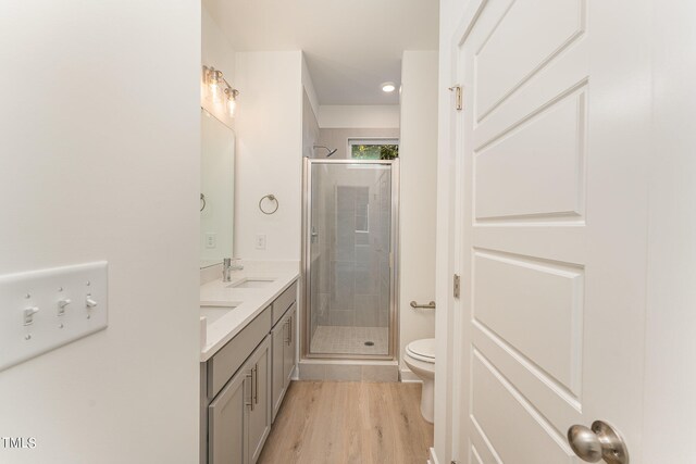 bathroom with toilet, an enclosed shower, vanity, and wood-type flooring