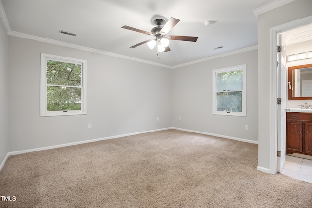 carpeted spare room with ceiling fan, plenty of natural light, and crown molding