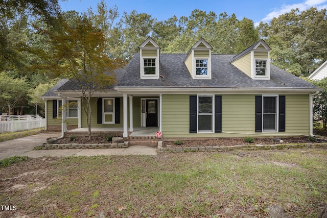 cape cod home featuring a porch and a front yard