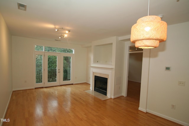 1001 Hillsborough St Unit 304, Raleigh, NC 27603 - unfurnished living room with wood finished floors, a fireplace with flush hearth, and a chandelier