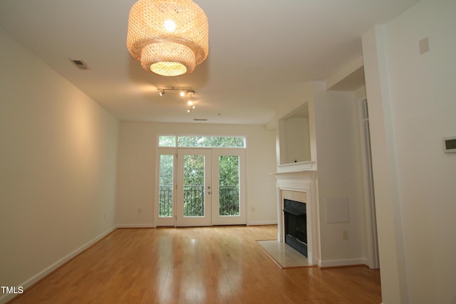 1001 Hillsborough St Unit 304, Raleigh, NC 27603 - unfurnished living room featuring light wood-style floors, a tile fireplace, and a chandelier