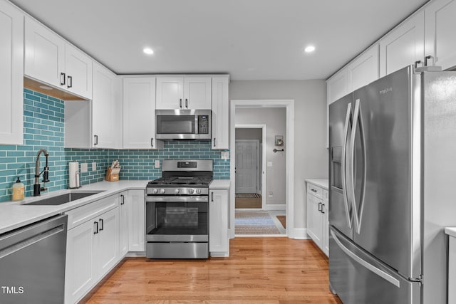 1209 Edgevale Rd, Durham, NC 27701 - kitchen with appliances with stainless steel finishes, light countertops, white cabinetry, backsplash, and recessed lighting