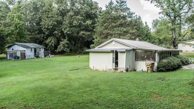 view of yard with a sunroom and a storage unit